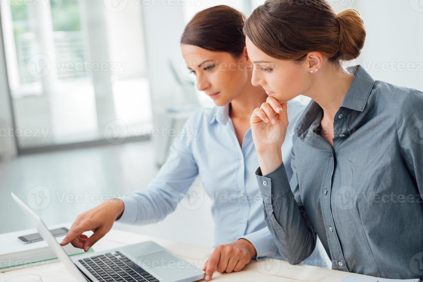 Business women working together on a laptop photo