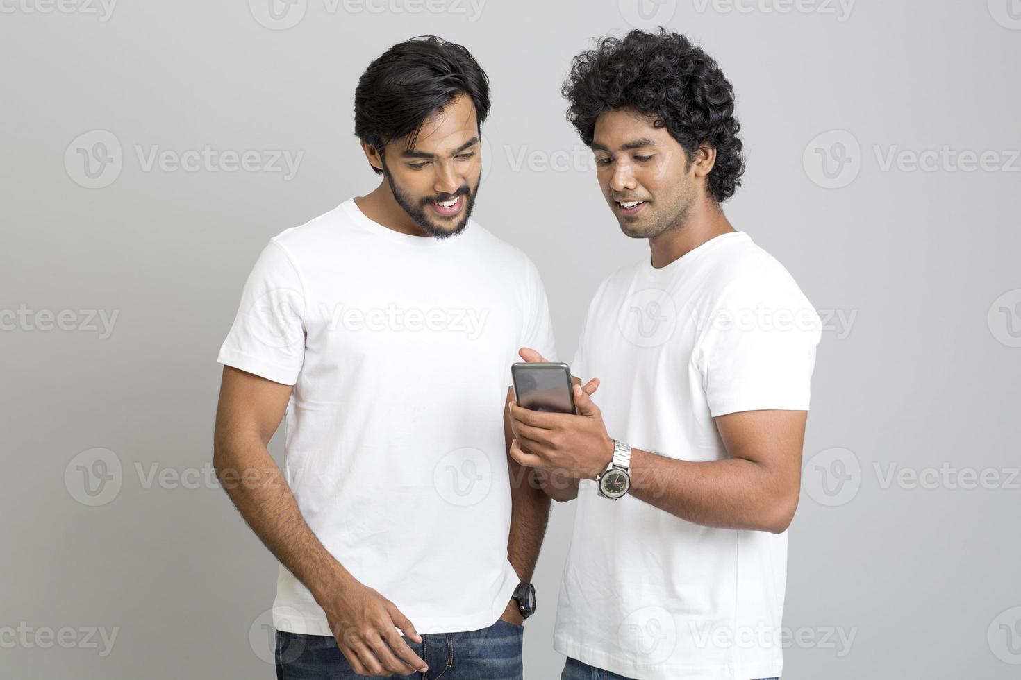 Happy two young men using smartphone photo