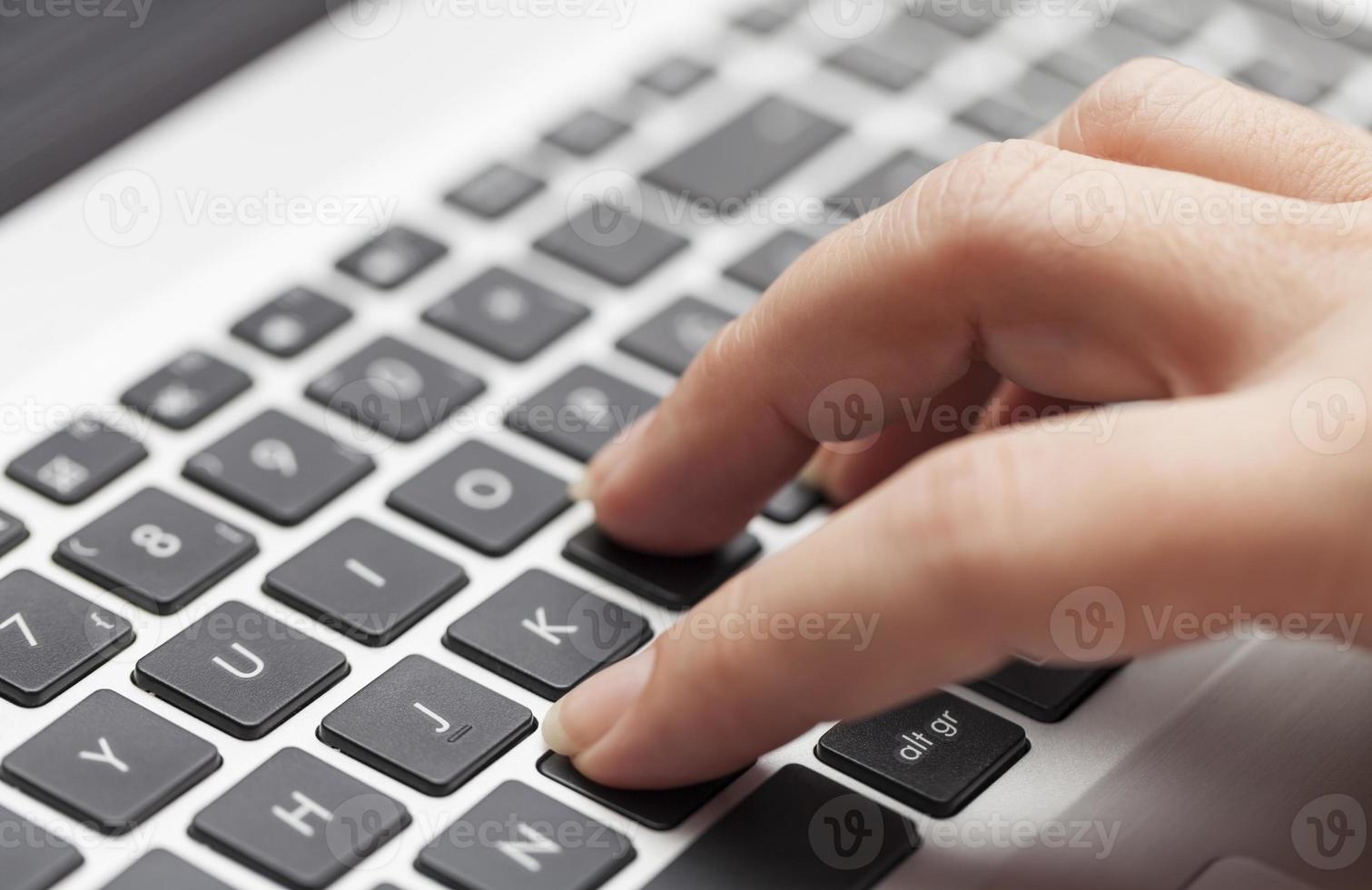 mujer escribiendo en la computadora portátil foto