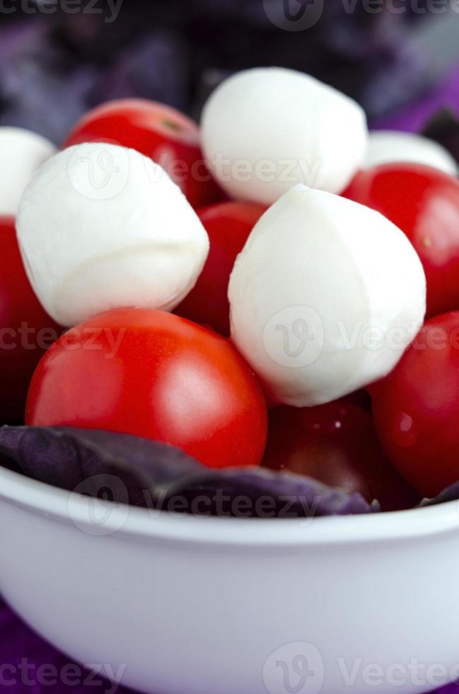 mozzarella y tomates cherry en un tazón de porcelana foto