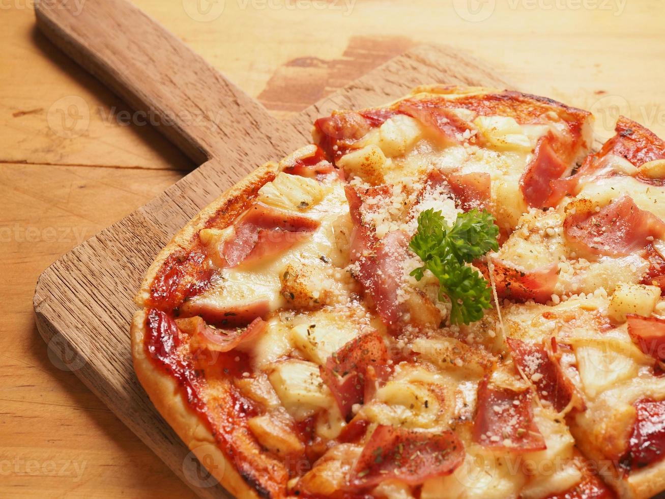 Hawaiin pizza on wood plate photo