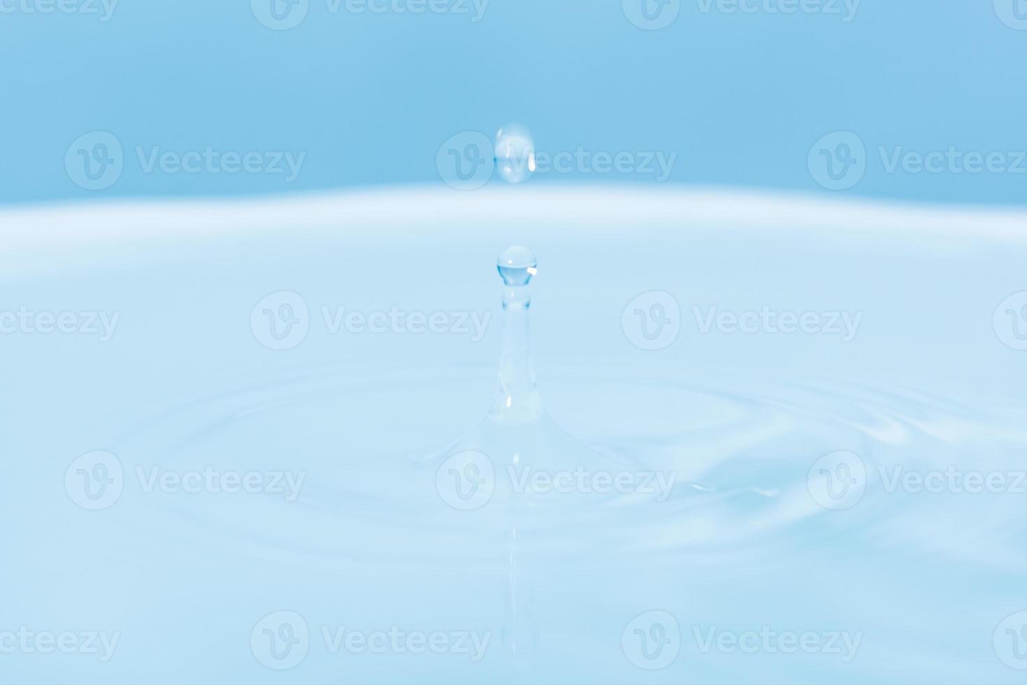 Water drop falling into water photo