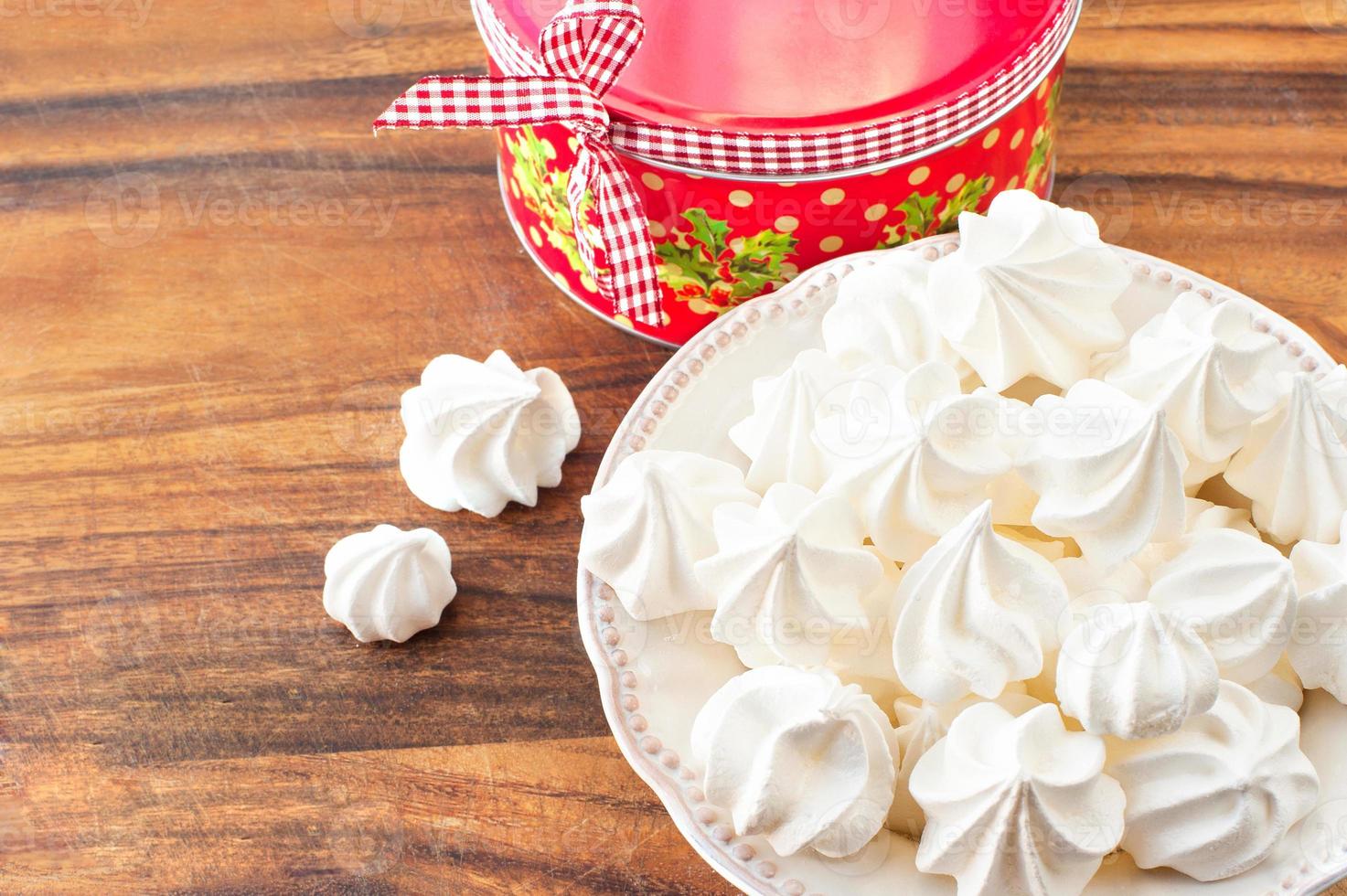 Many small white meringue cookies with round christmas gift box photo