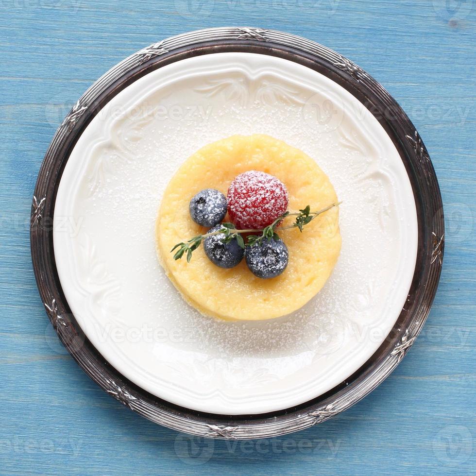 Lemon delicious pudding cake  served with berries photo