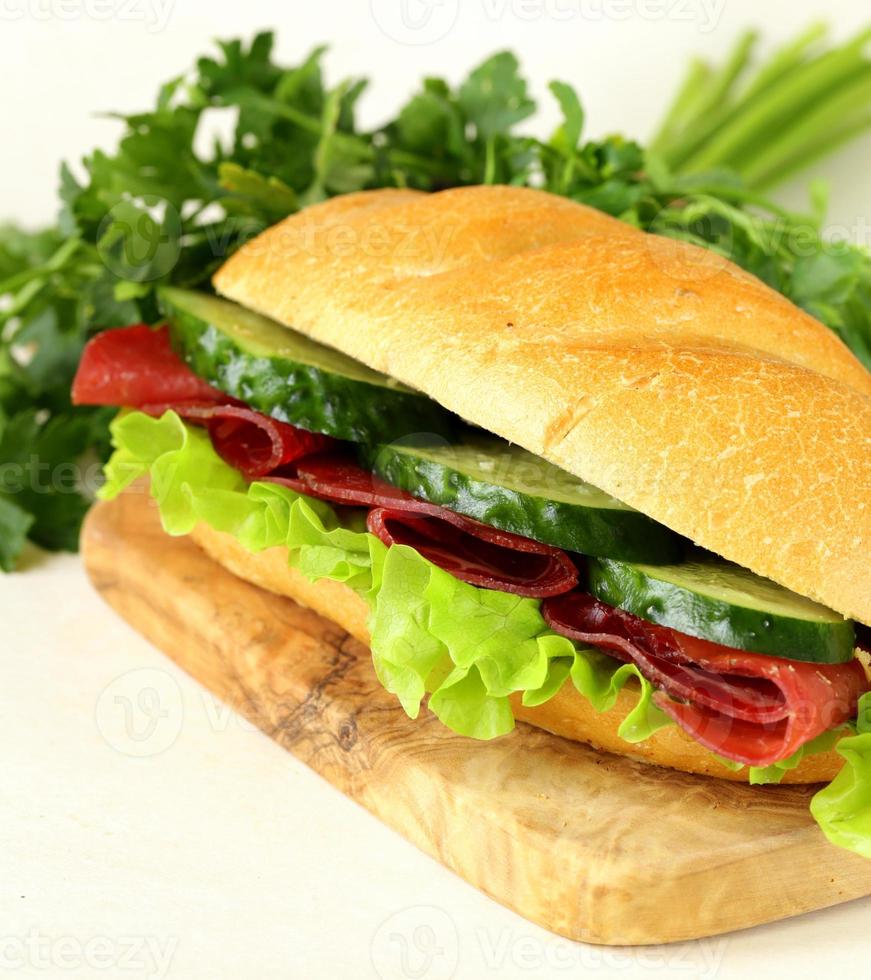 sandwich fresco con carne ahumada, pepino y lechuga foto