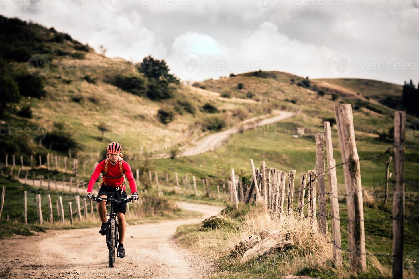 Ciclista de montaña montando en inspirador paisaje de otoño foto