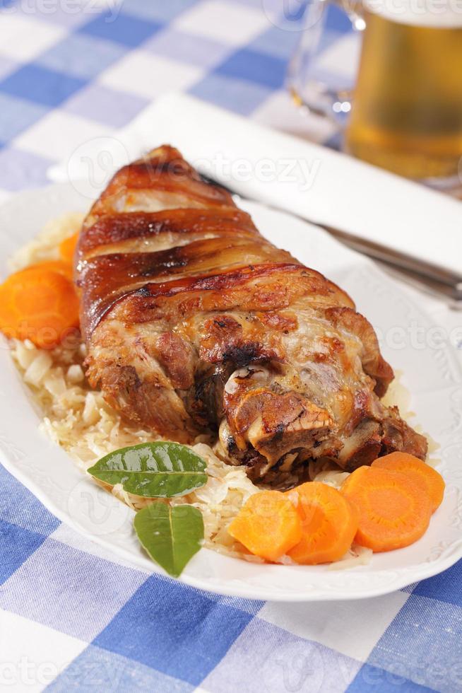 Eisbein, roasted pork knuckle with braised cabbage and beer photo