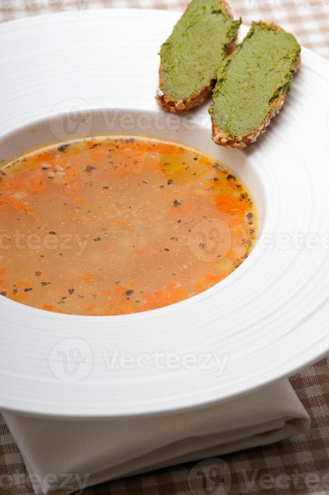 Italian minestrone soup with pesto crostini on side photo