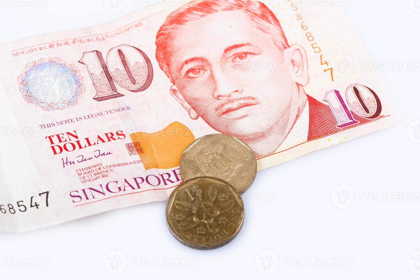 Billete de dólar de Singapur y monedas sobre fondo blanco, foto