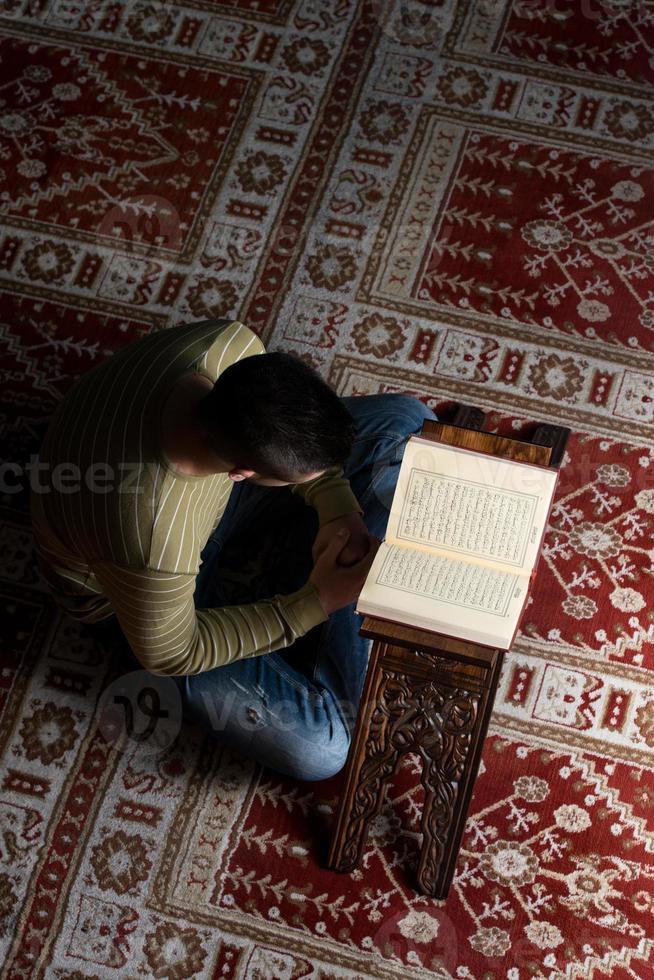hombre musulmán está leyendo el Corán foto