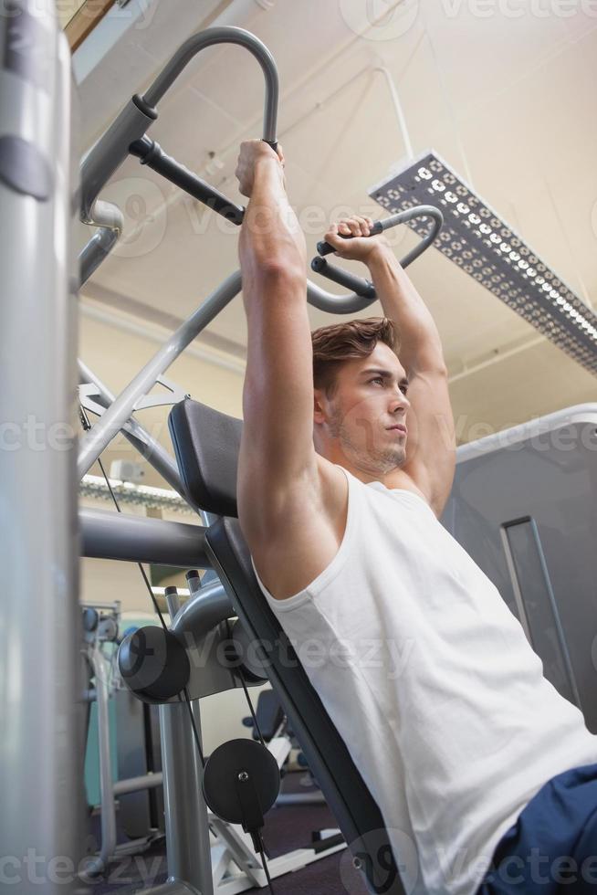 Fit man using weights machine for arms photo