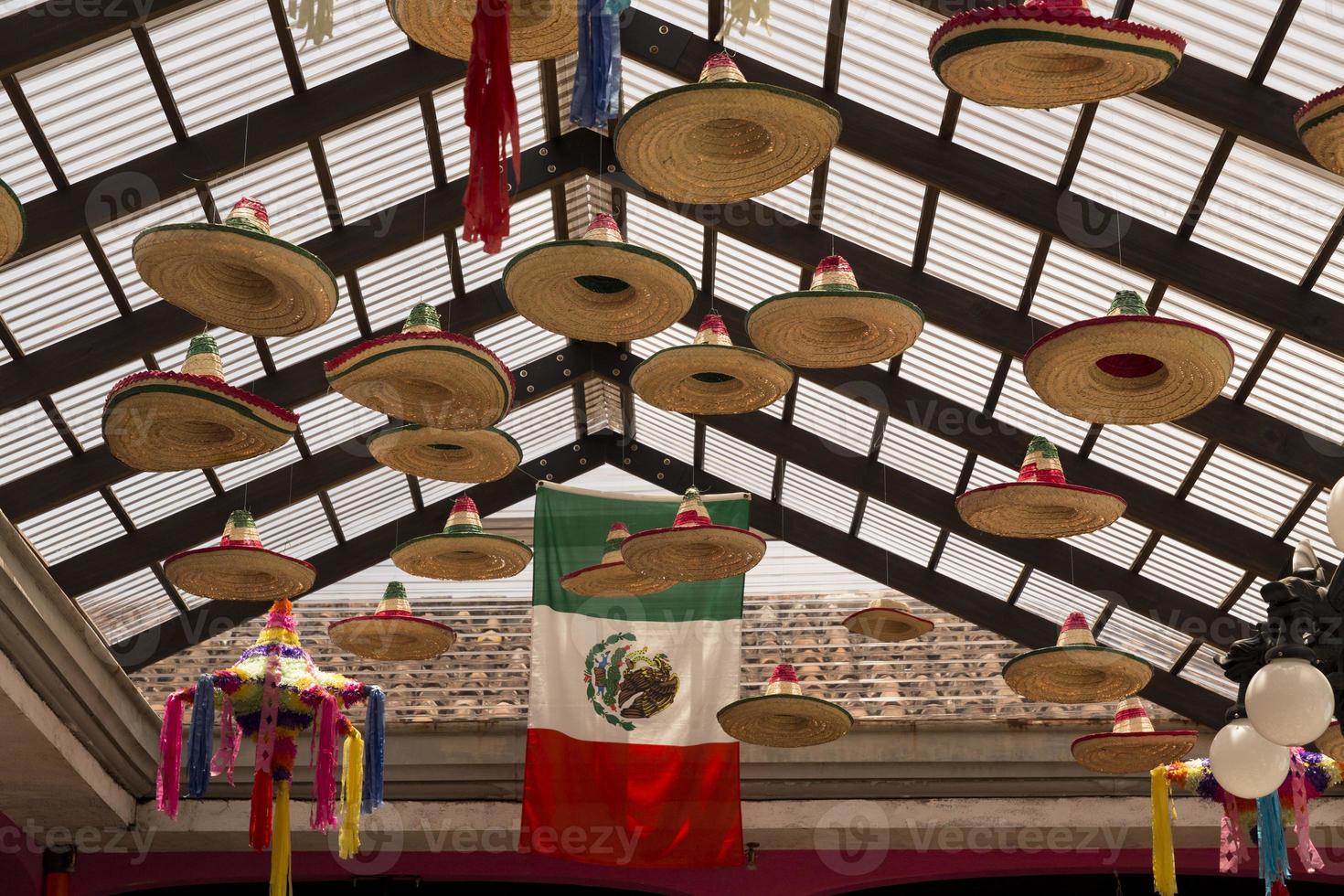 Mexican sombreros hanging down from a glass roof photo