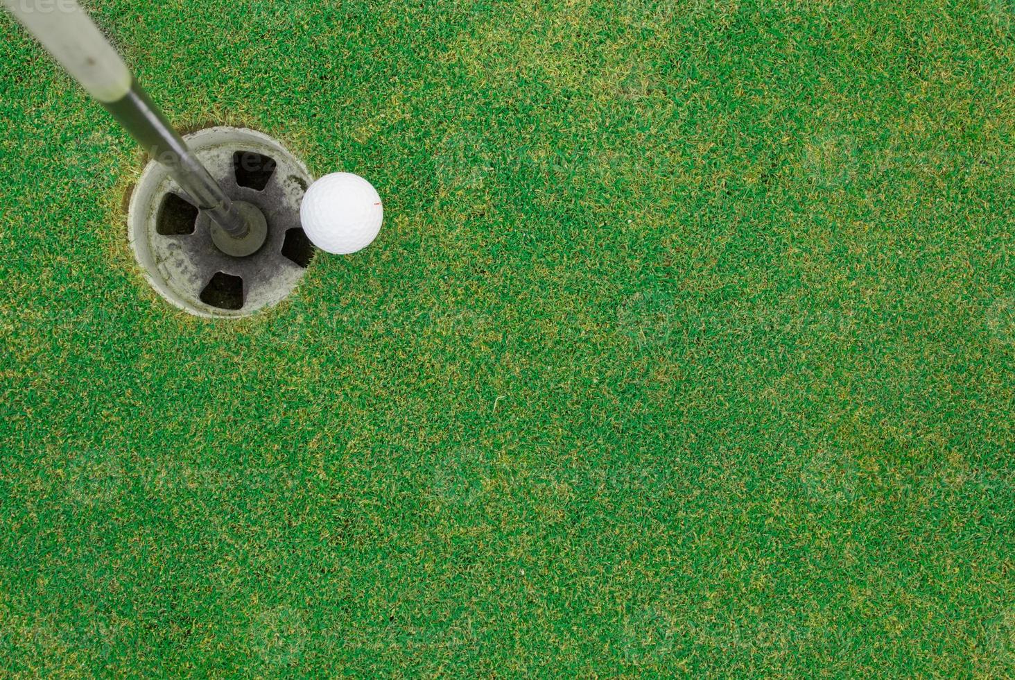 pelota de golf cerca del hoyo foto