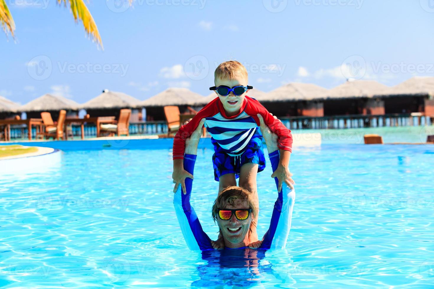 padre e hijo se divierten en la piscina foto