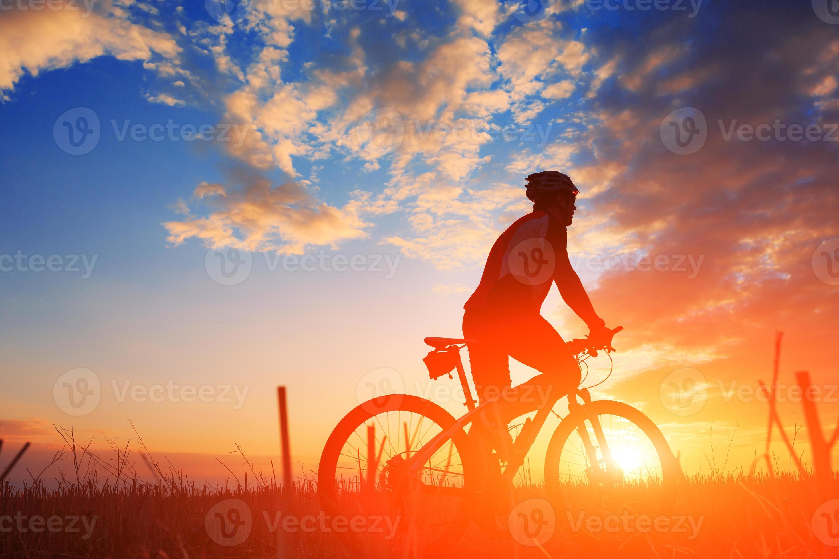 Silhouette of a biker and bicycle on sunset background. 824722 Stock Photo  at Vecteezy