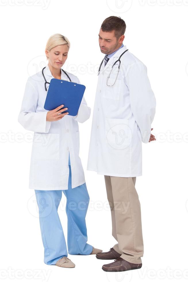 Doctors discussing something on clipboard photo