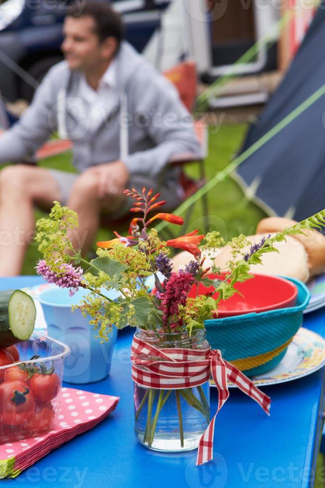 mesa de decoración de flores silvestres en vacaciones familiares de camping foto