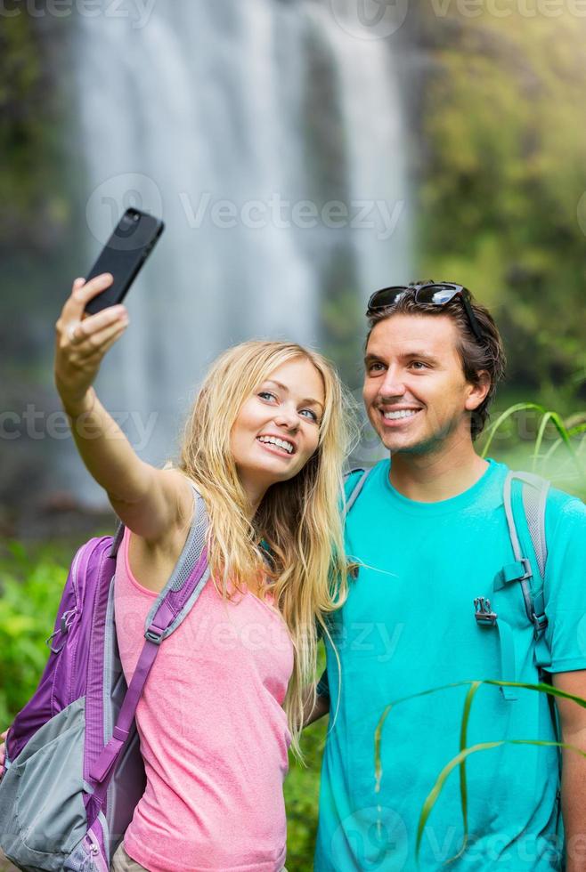 Couple having fun taking pictures together outdoors on hike photo