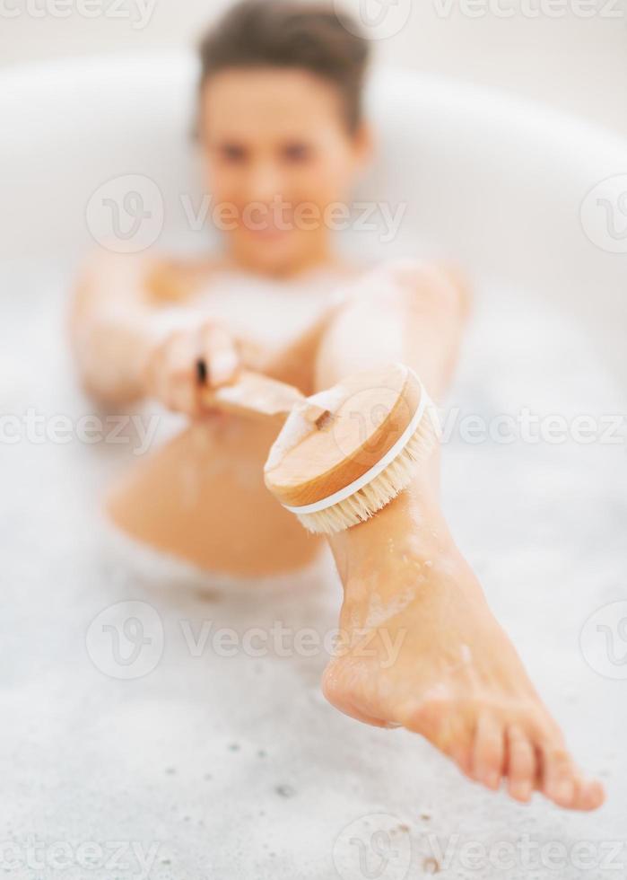 Primer plano de una mujer joven que se lava en la bañera foto