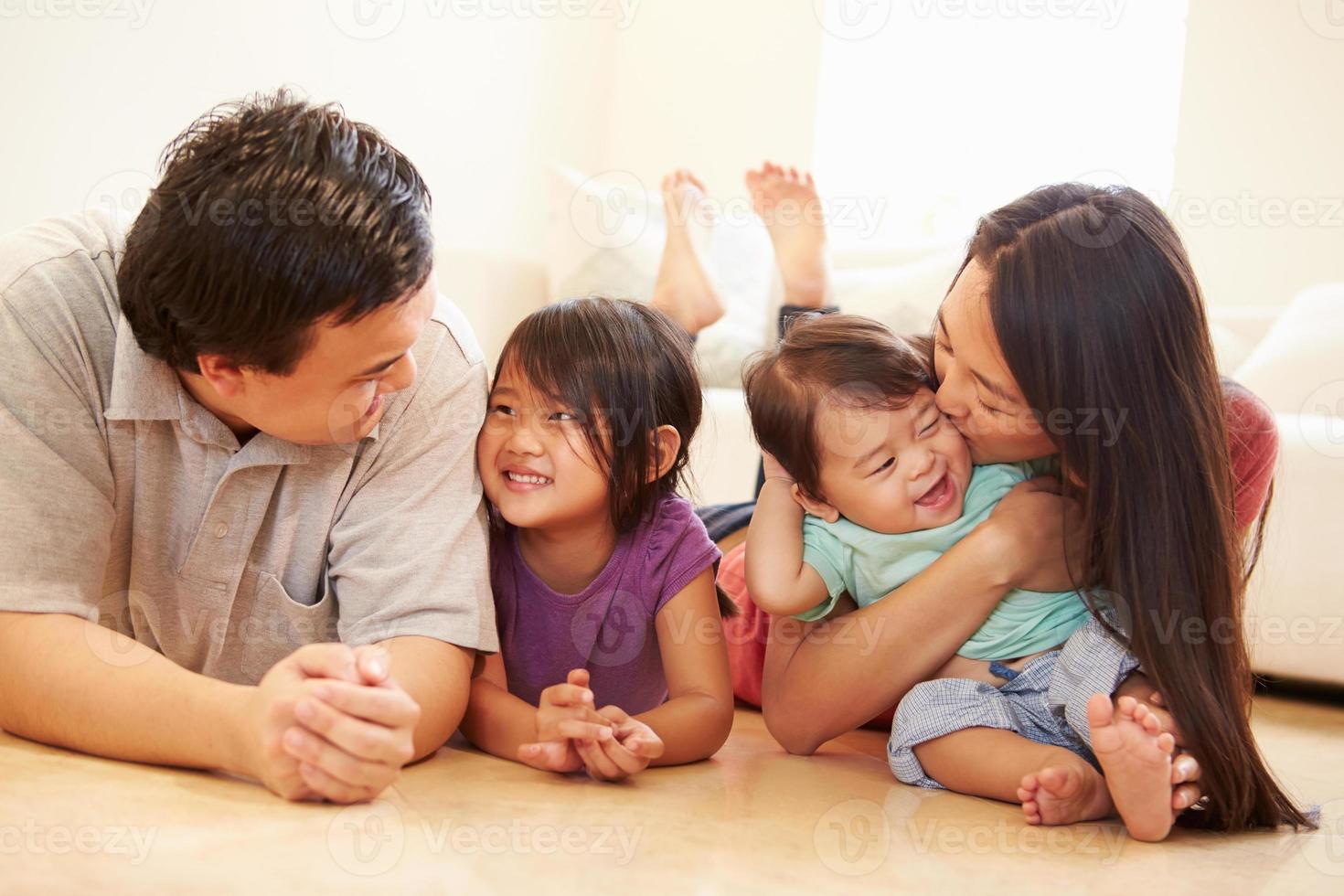 Portrait Of Family Lying On Floor At Home photo