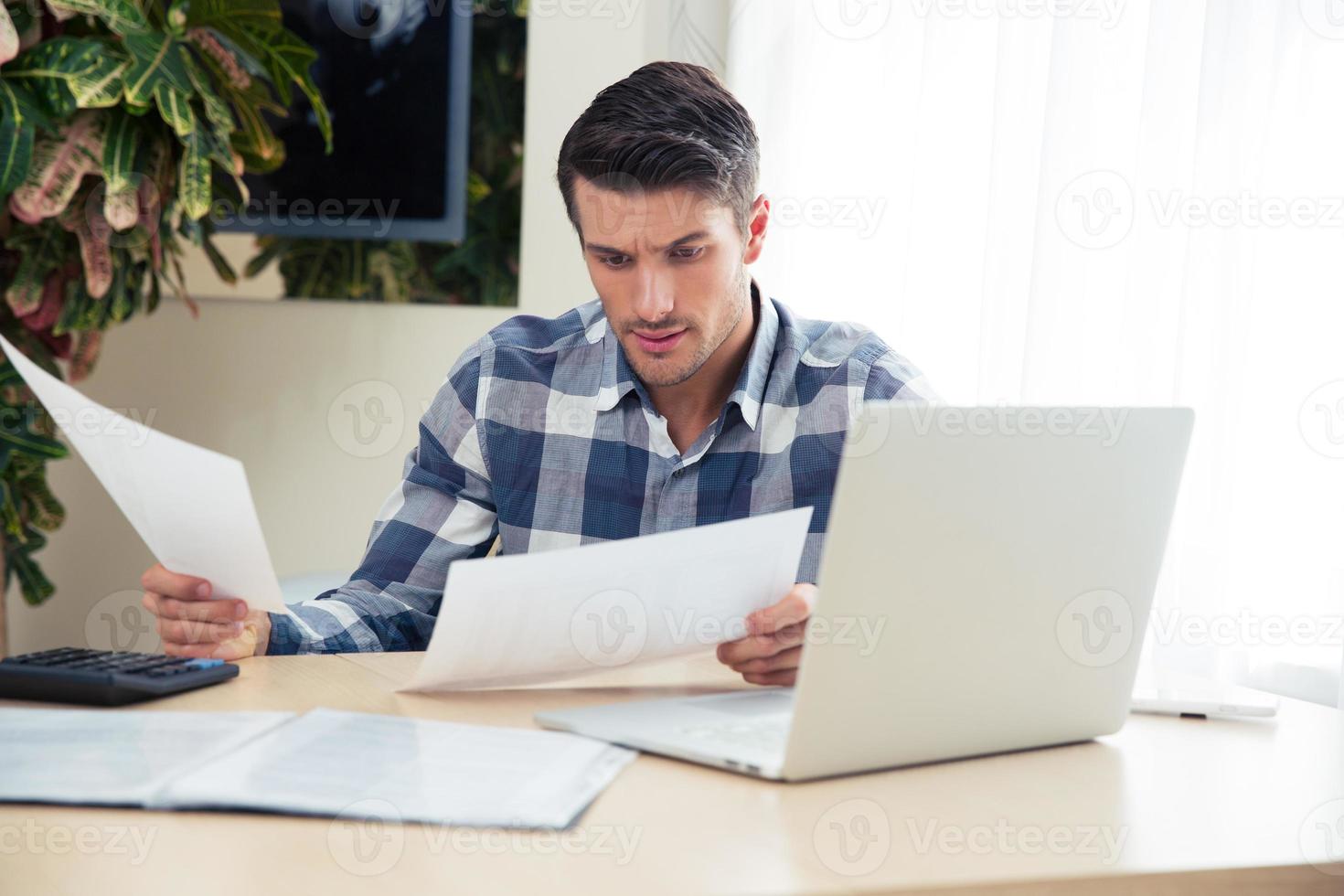 hombre trabajando con facturas en casa foto