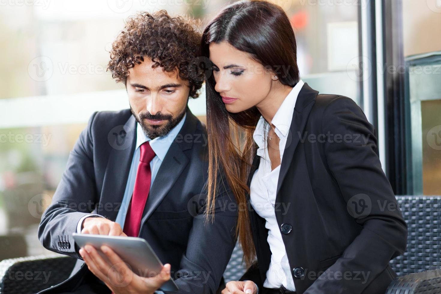 Two business people using a digital tablet photo