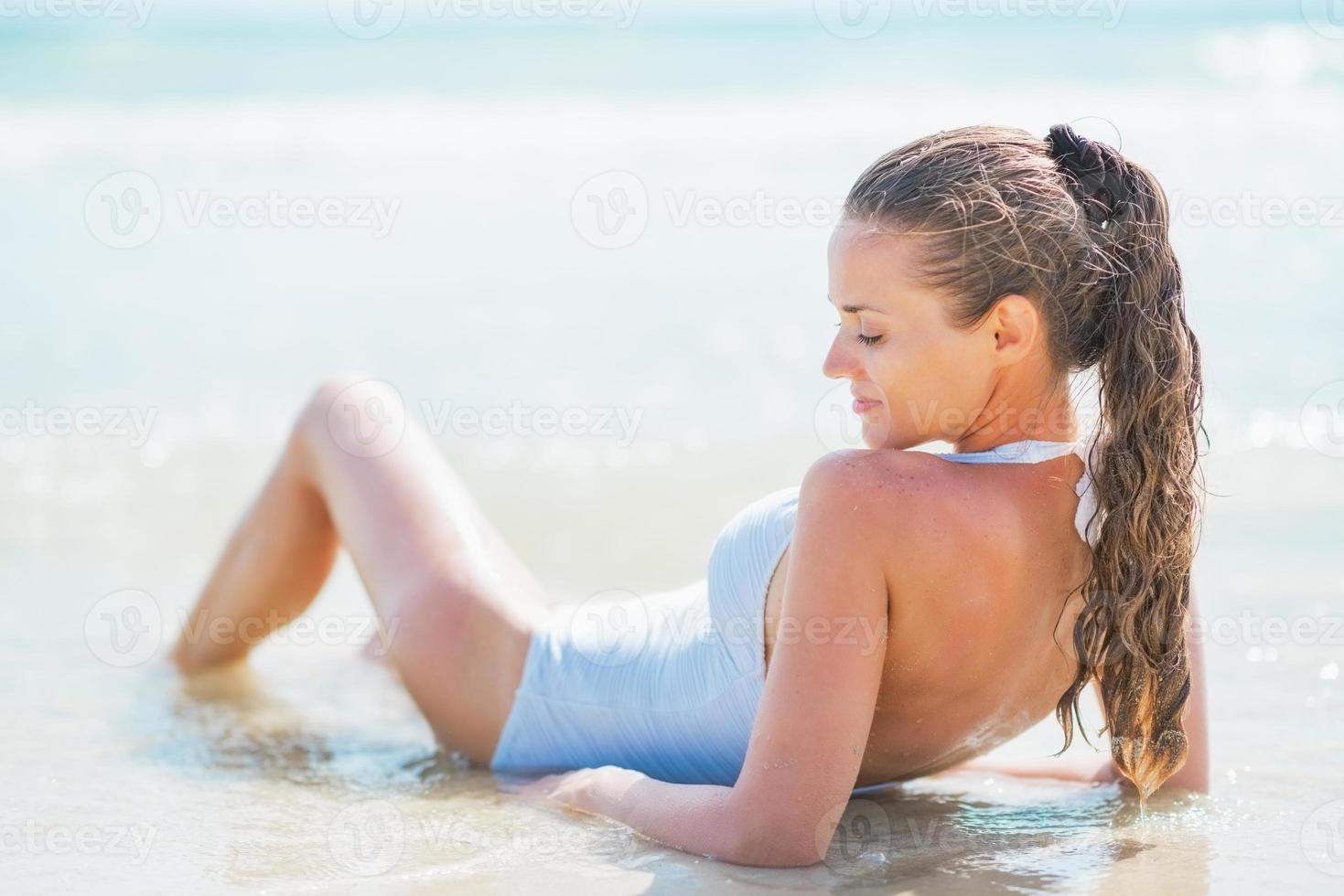 mujer joven relajada en traje de baño en el mar. vista trasera foto