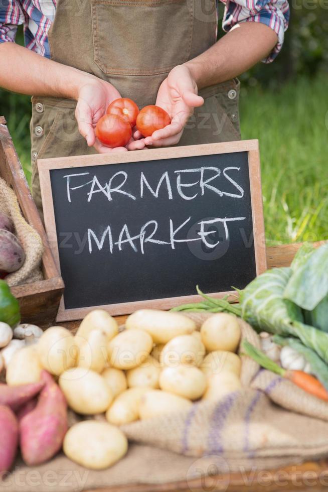 agricultor vendiendo verduras orgánicas en el mercado foto