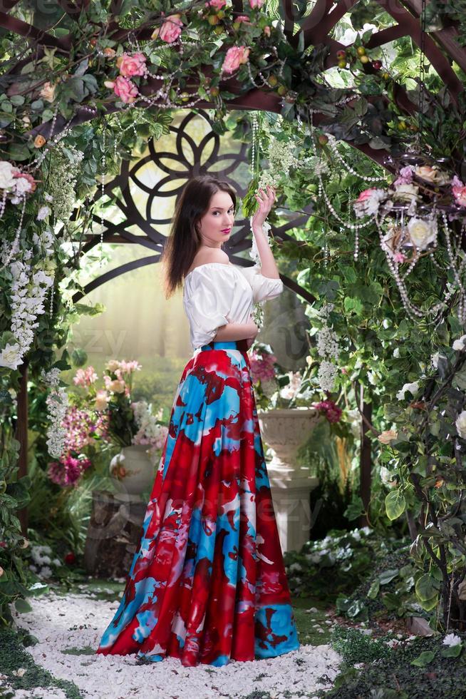 atractiva mujer de en una larga falda roja en jardín de flores 835734 Foto stock en Vecteezy
