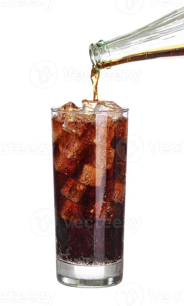 Coca-Cola vertiendo botella en vaso con cubitos de hielo aislado foto