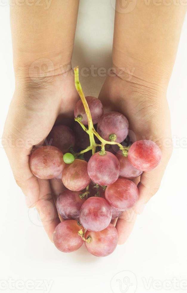 asimiento de la mano de uva roja foto