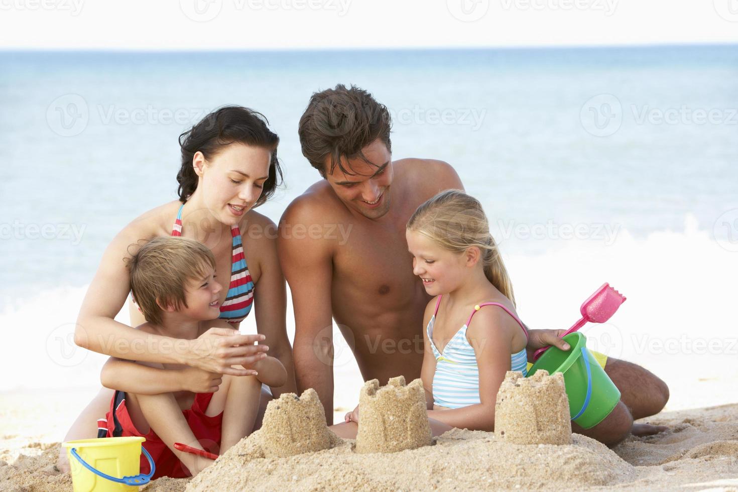 Retrato de familia disfrutando de vacaciones en la playa foto