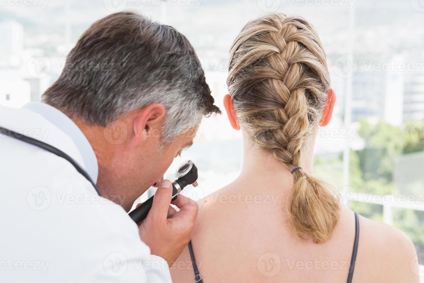 Doctor examining a spot at his patient photo