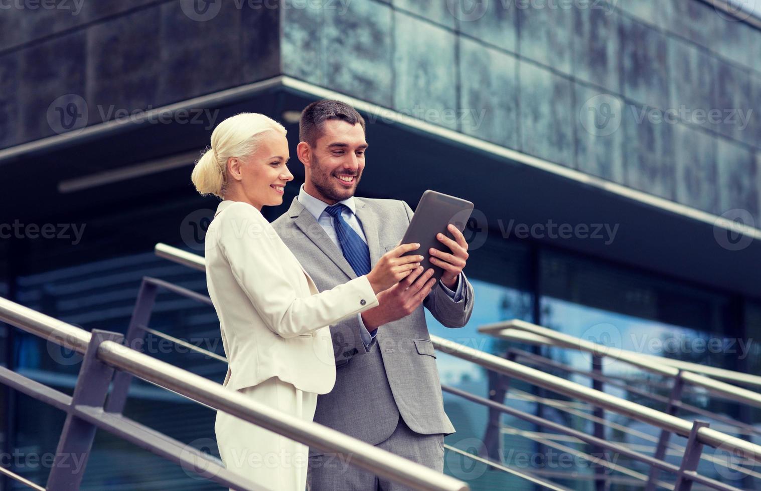 empresarios sonrientes con tablet pc al aire libre foto