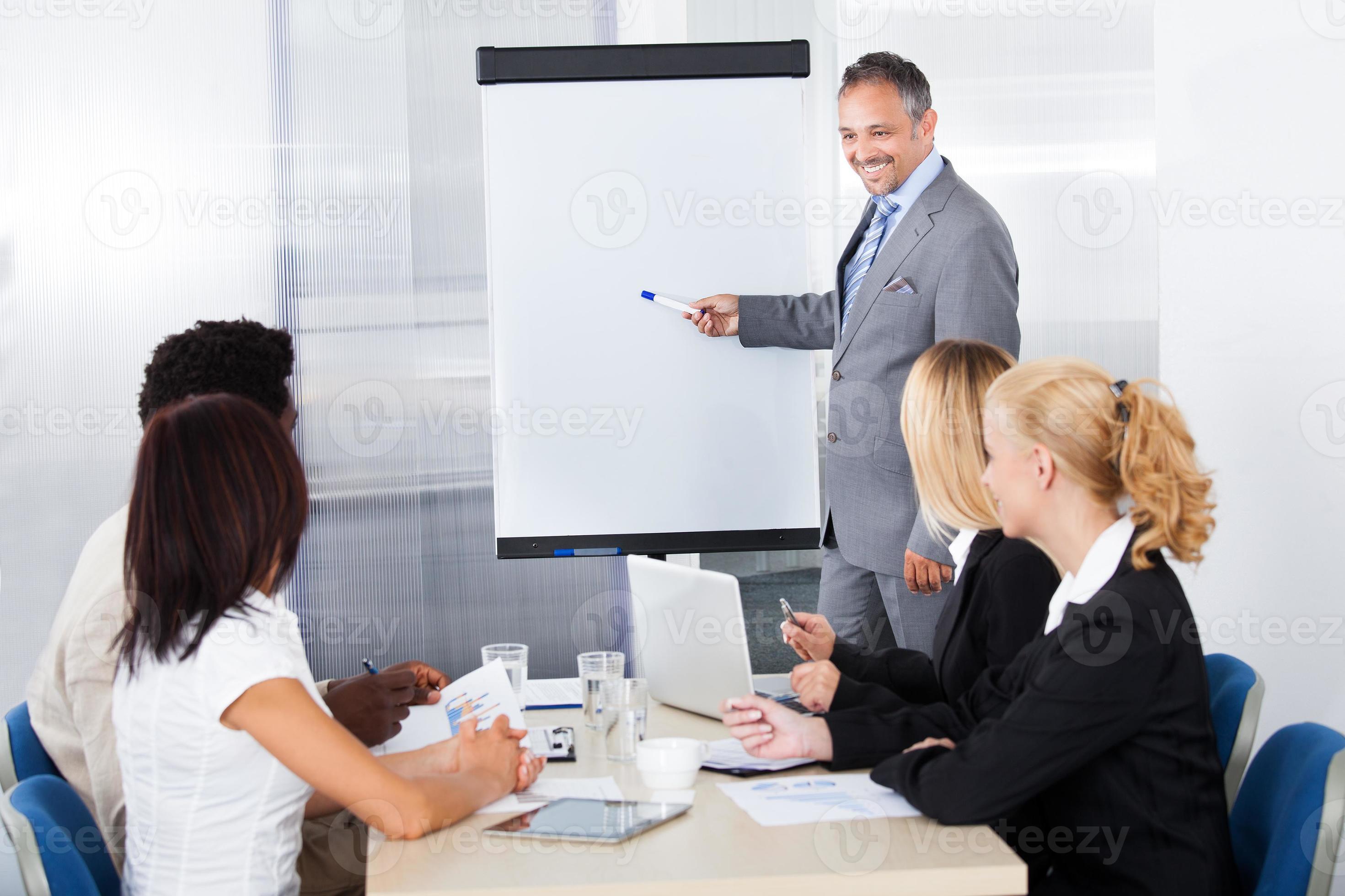 Businesspeople Looking At Man Explaining photo