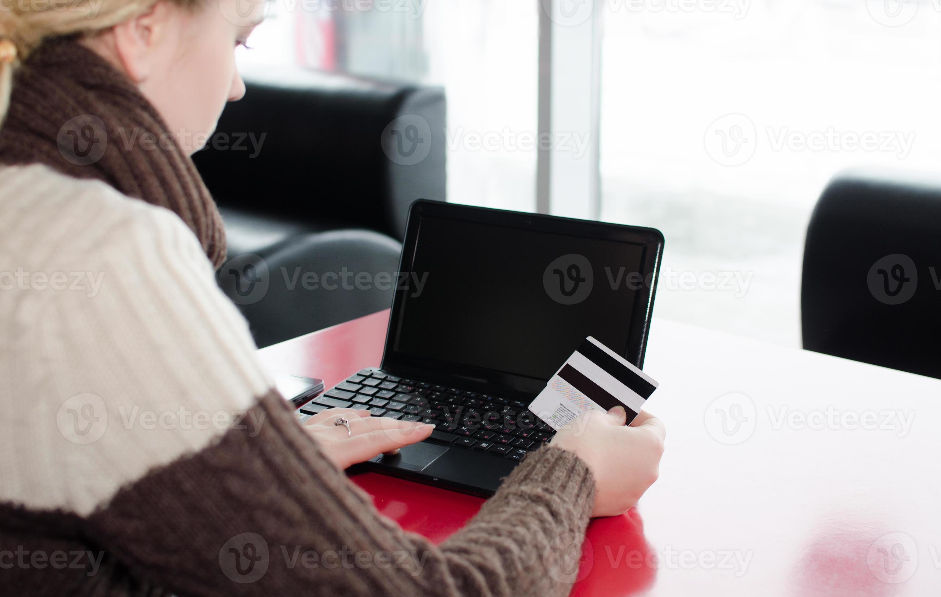 Primer plano mano mujer usando laptop y tarjeta de crédito, compras en línea foto