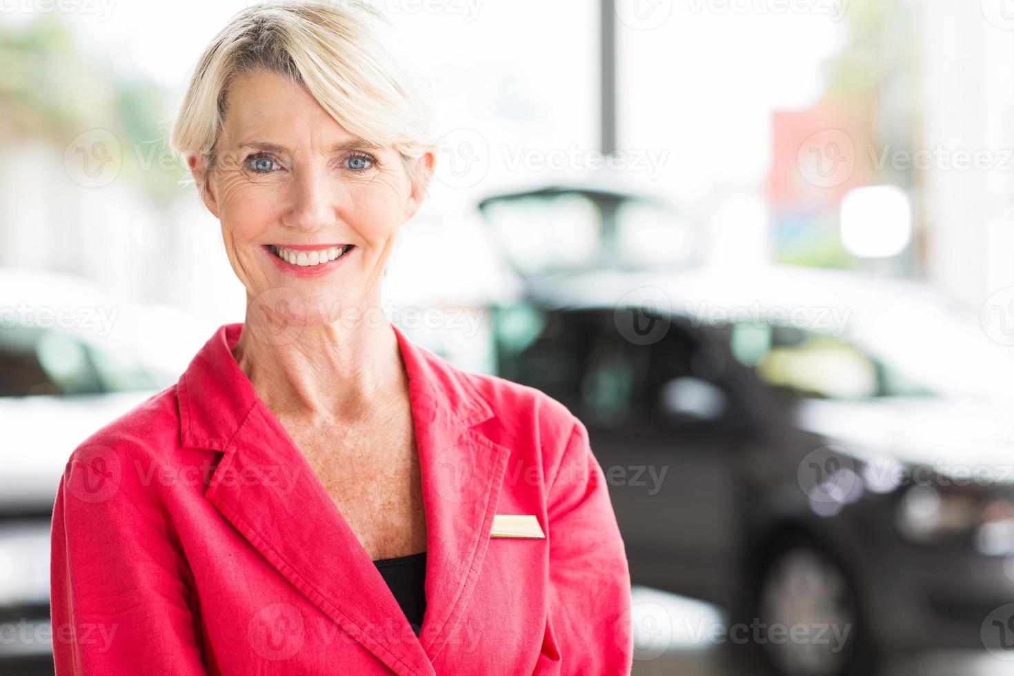 Senior mujer trabajando en concesionario de automóviles foto