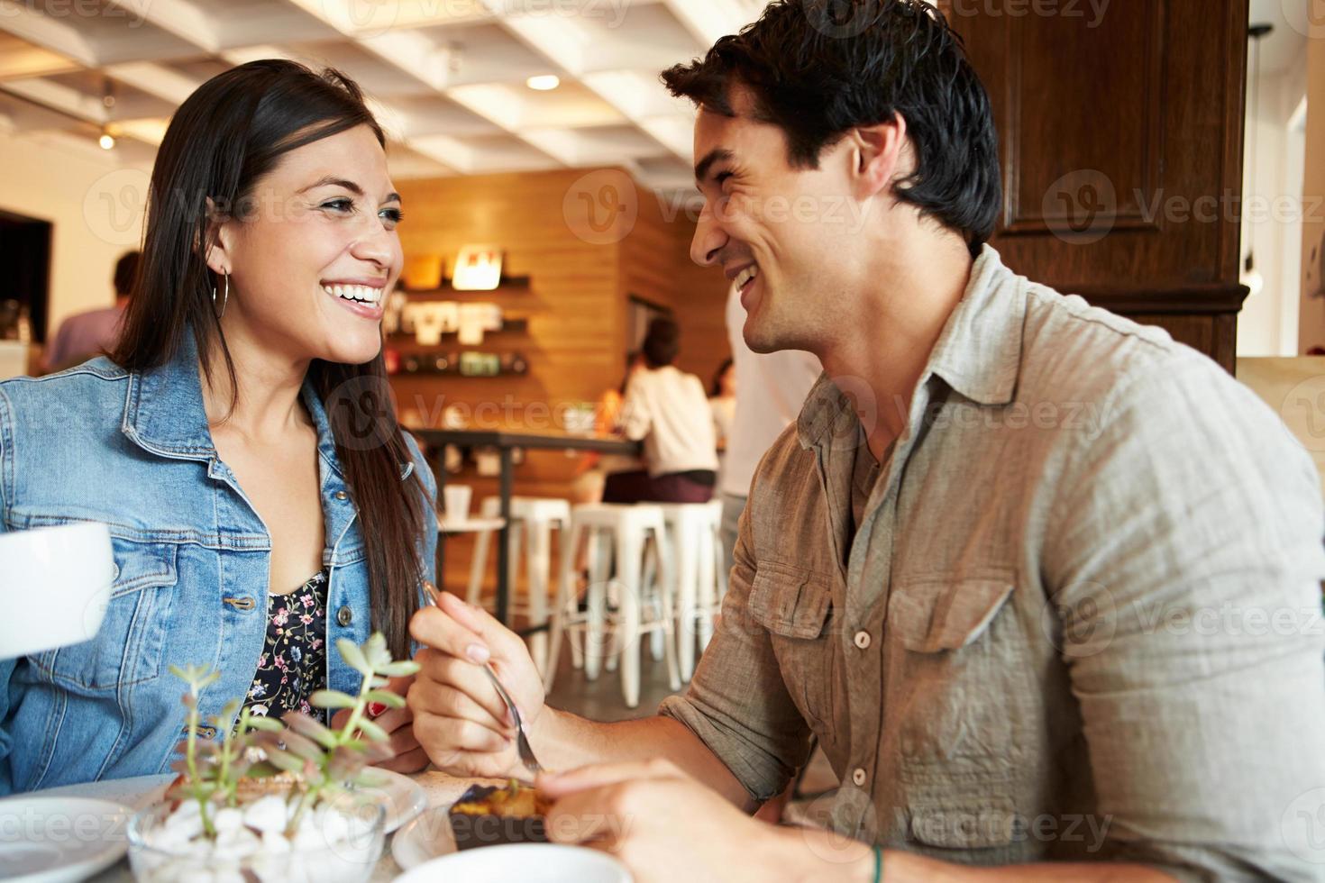 Reunión de pareja en el concurrido café restaurante foto