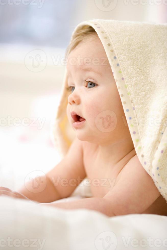 Baby girl (9-12 months) wearing towel on head, close-up photo