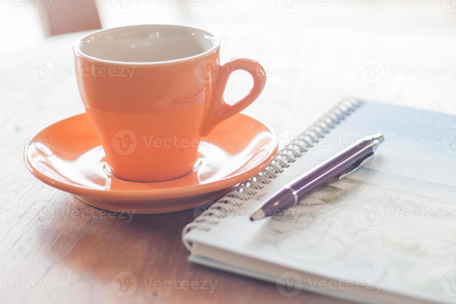 Cup of coffee with pen and spiral notebook photo