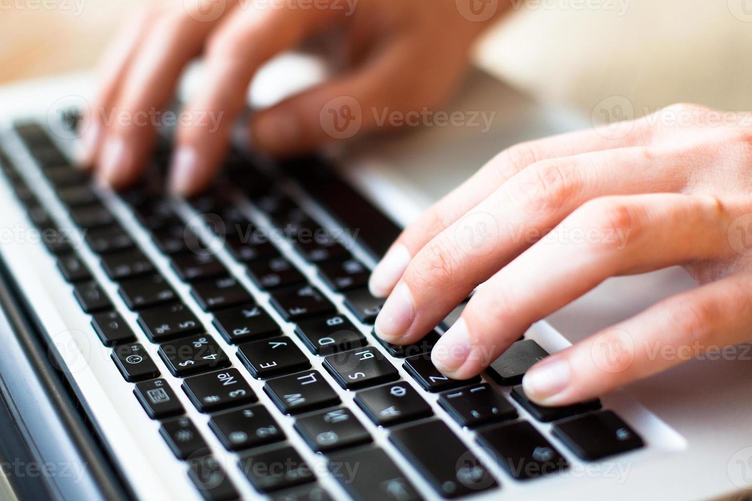 manos escribiendo en el teclado del portátil foto