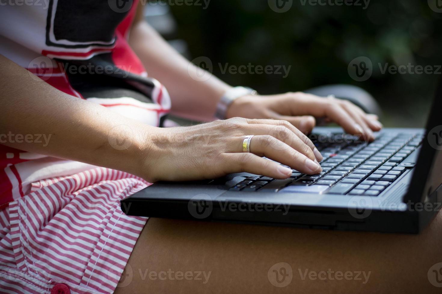 mujer manos closeup usando laptop en el parque foto