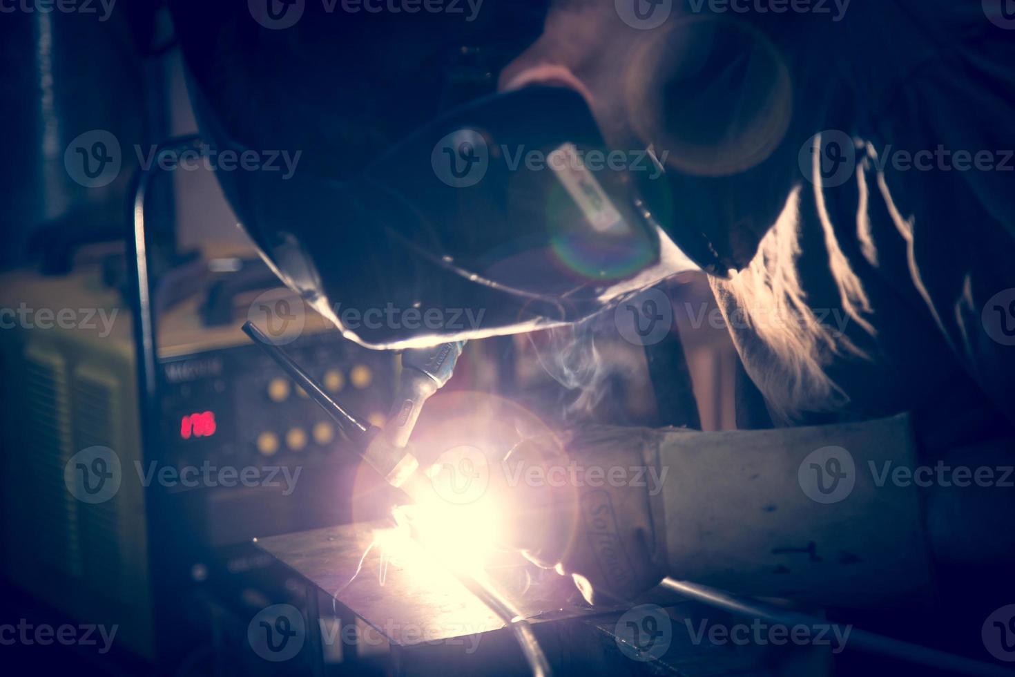 Employee welding aluminum using TIG welder. photo
