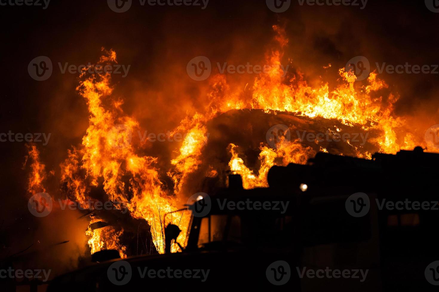 Burning fire flame on wooden house roof photo