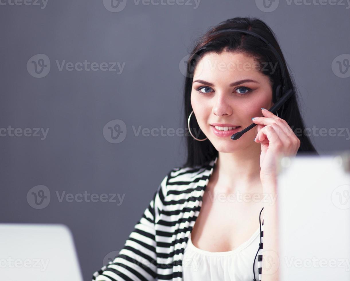 Beautiful business woman working at her desk with headset and photo