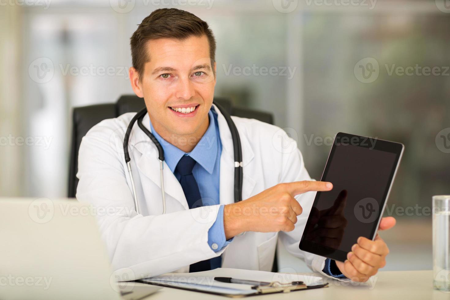 joven médico señalando tablet PC foto