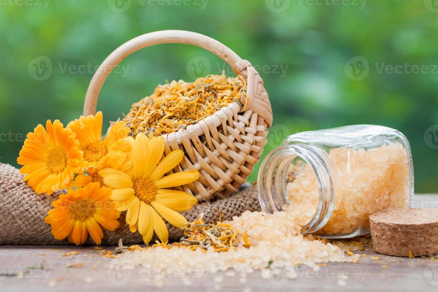 Marigold flowers, basket with dried plants and sea salt photo