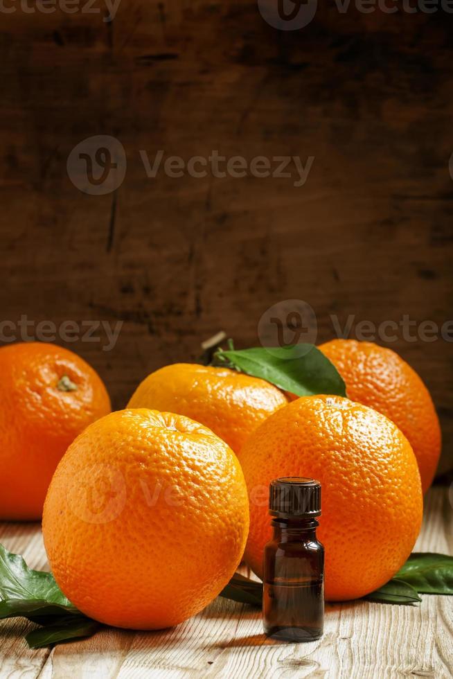 Orange oil in a small bottle and fresh fruit photo