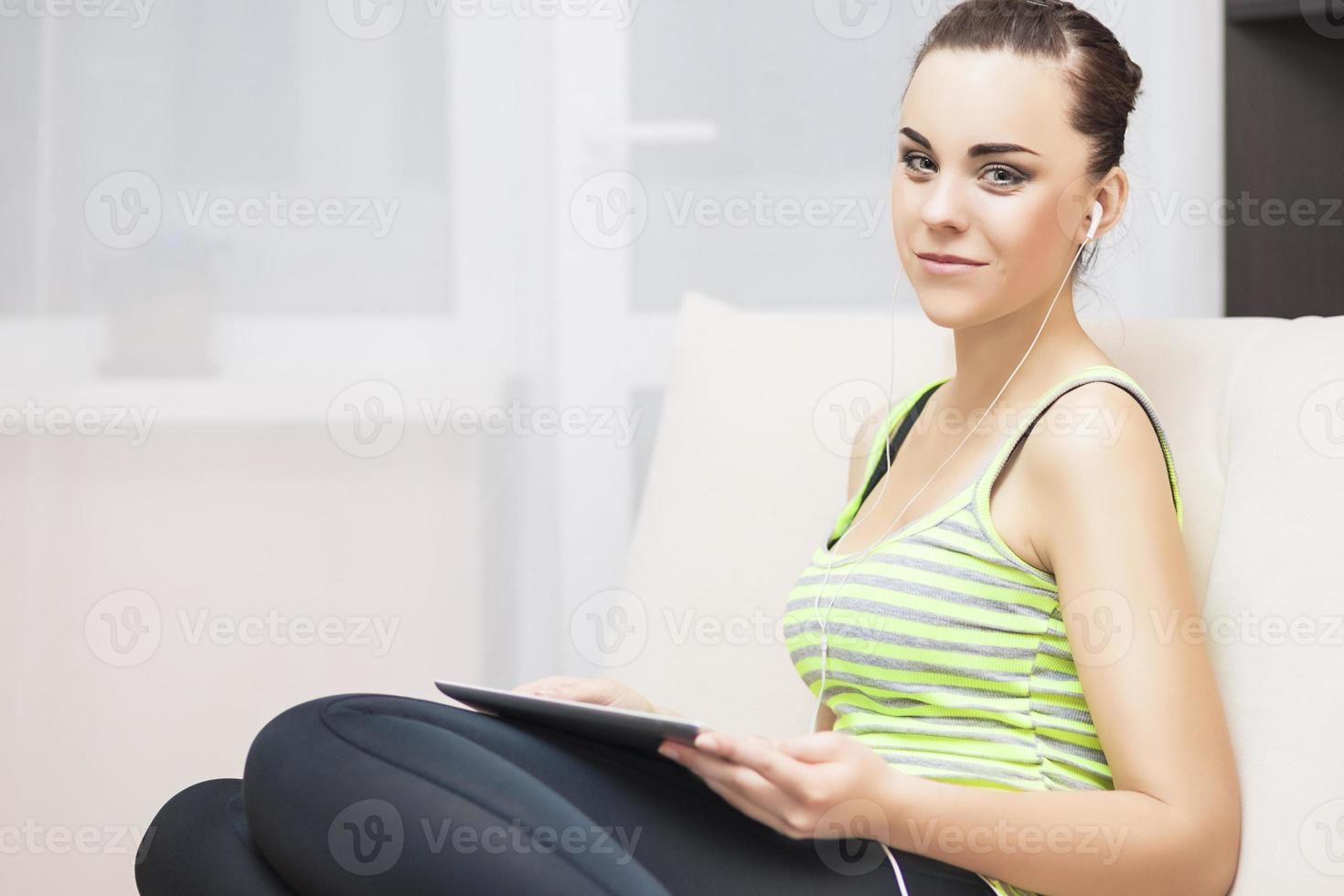 Caucasian Female With Headphones Using Tablet at Home Environment photo