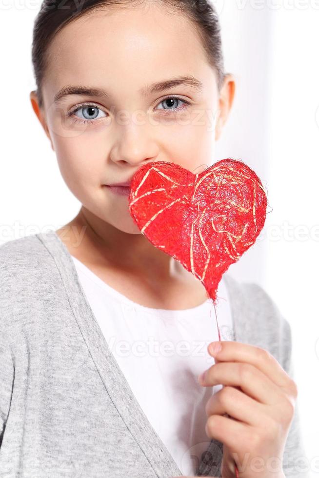 niña caucásica con corazón rojo de San Valentín foto
